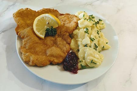 Schnitzel "Wiener Art" (Schwein) mit Kartoffelsalat, Preiselbeeren, Zitrone