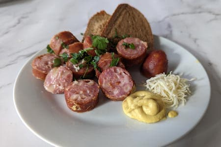 Käsekrainer mit Senf, Kren, Brot oder mit Sauerkraut